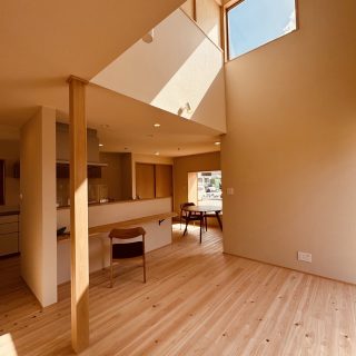 窓から青空を眺める吹き抜けリビング
